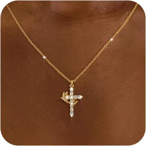 Detail shot of golden cross pendant necklace featuring crown and sparkling crystals