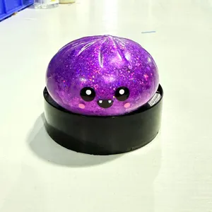 Nahaufnahme eines lila glitzernden Brötchen-Quetschspielzeugs mit süßem Cartoon-Gesicht.