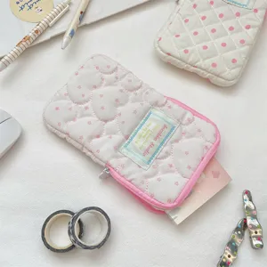 Détail de trousse matelassée mignonne, pochette de papeterie esthétique rose macaron douce.