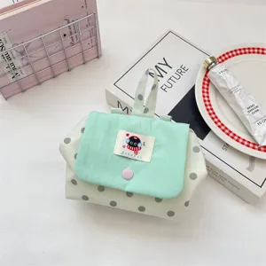 Mint green polka dot cosmetic pouch portable storage bag with flap and cute cartoon label.