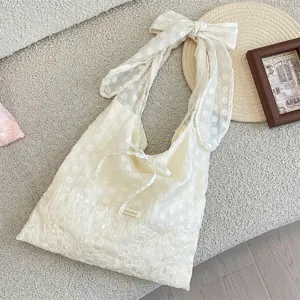 Chic polka dot organza tote bag with elegant bow shoulder strap and floral lace trim detail.