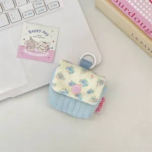 Detailansicht der kleinen Stoff-Kopfhörertasche mit floralem Kord-Überschlag und Druckknopf.