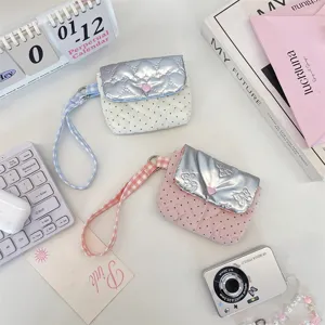 Gesteppte Polka-Dot-Handgelenktasche mit metallischer Silberklappe und Herzverschluss.