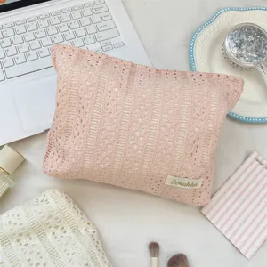 Zarte rosa hohle Spitzendetails der Kosmetik-Reisetasche, elegantes feminines Design.
