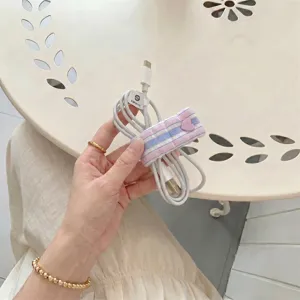 Detail shot of the pastel plaid cord organizer with cute pink heart button for tidy cables.