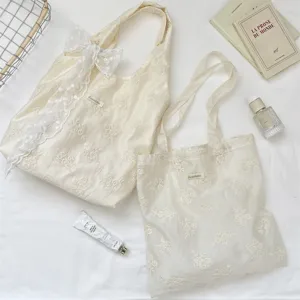 Embossed floral canvas tote bag featuring delicate bow detail and vintage aesthetic style.