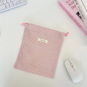 Detailansicht der rosa Stoffaufbewahrungstasche mit Punkten und praktischem Kordelzug.