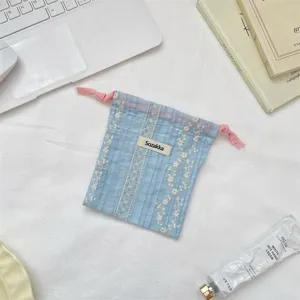 Nahaufnahme Detail des blauen karierten Beutels mit feiner Spitzenstickerei und Kordel.