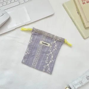 Detailansicht der weichen Spitzen-Stofftasche mit gelben Kordeln, ideal für Kosmetikartikel.