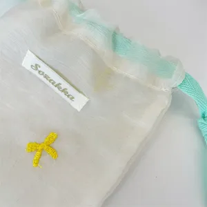 Mintgrüner Kordelzug Mesh Beutel mit gelber Schleife für Kosmetik und kleine Reiseutensilien.