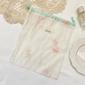 Macaron organza opbergtas met fijn bloemborduurwerk voor het opbergen van kleine spullen.