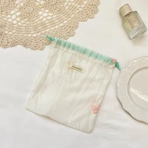 Macaron kleur organza opbergtas met schattige bloemenborduurwerk en groen koord.