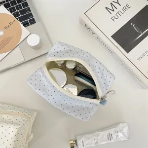 Vista dettagliata della simpatica borsa cosmetica a pois con interno e chiusura lampo.