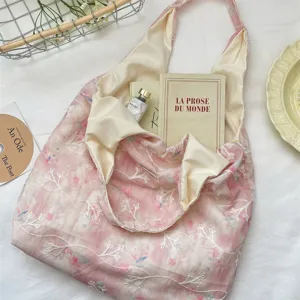 Pink floral embroidered canvas hobo shoulder bag with cream lining, soft aesthetic detail.