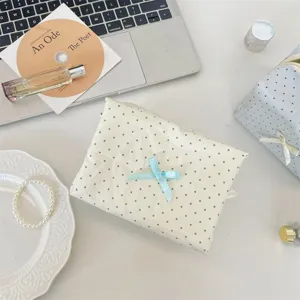 Dettaglio della borsa per trucco a pois stile coreano con grazioso fiocco per viaggio e ufficio.