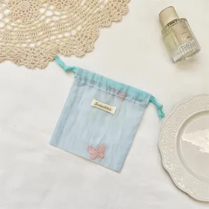 Macaron kleur organza opbergtas met schattige vlinder borduurwerk voor sieraden en cosmetica.