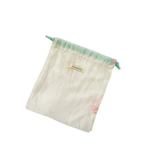 Macaron organza opbergtas met delicate madeliefjes borduurwerk en een handig trekkoord.