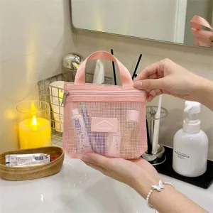 Pink mesh cosmetic bag detail shot, portable zipper makeup pouch and travel toiletry organizer.