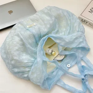 Gedetailleerd overzicht van de lichte blauwe organza geplooide schoudertas met stippen.