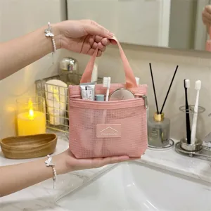 Minimalist pink mesh cosmetic bag with zipper and handle, perfect travel toiletry pouch detail