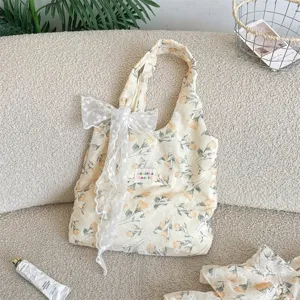 French style yellow floral fabric shoulder bag with elegant white lace bow for casual travel.