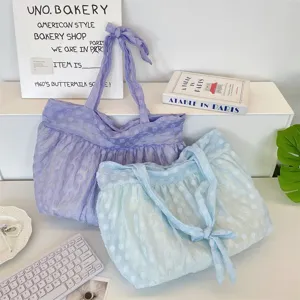 Gedetailleerd overzicht van organza stippen tote bag, doorschijnende geplooide stof met knoopriem.