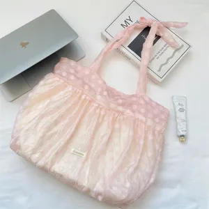 Detailopname van de roze polkadot organza geplooide shopper met gestrikte schouderband.