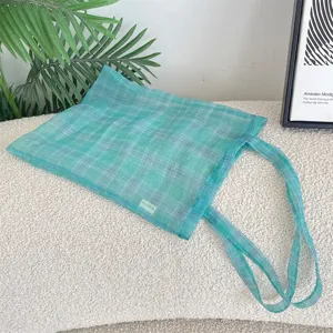Detailansicht der grünen karierten Organza-Tasche mit transparentem Stoff und weicher Textur.