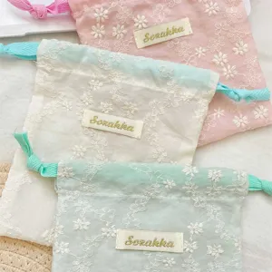 Gros plan detail du sachet cordon floral brode en tissu de gaze douce rangement sac.
