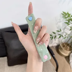 Close-up view of the cute snap button cable organizer strap, showing detailed clasp and cute design.