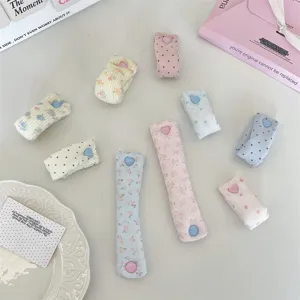 Cute fabric data cable organizer strap with heart snap button, macaron floral pattern details.