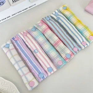 Detailed view of colorful plaid fabric cable organizers with cute heart-shaped snap buttons.