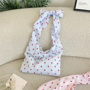 Blue gingham shoulder bag with red print and large bow strap, cute casual daily style.