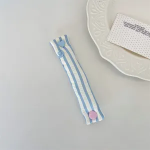 Blue and white striped fabric cable organizer detail view with cute heart button closure.