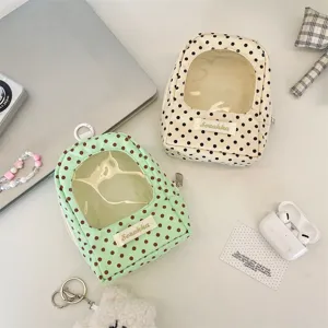 Detailed view of polka dot doll storage bag with clear window and zipper closure.