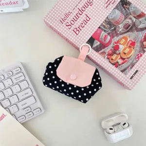 Detailansicht der niedlichen schwarz-weißen Pünktchen-Tasche mit rosa Klappe und Aufhängeöse.