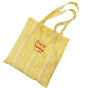 Gelb-weiße vertikal gestreifte Canvas Tote Bag, strukturierte Schultertasche für Reisen.