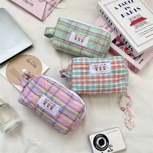 Borsetta cosmetica trapuntata a quadri con manico e etichetta carina. Ideale per viaggi e trucco.