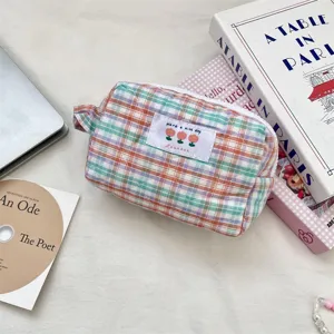 Dettaglio della trousse per cosmetici trapuntata a quadri colorati dalla texture morbida.
