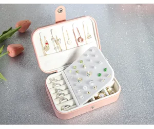 Pink PU leather jewelry box detail showcasing multi-functional ring slots and necklace hooks.