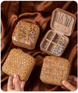 Compact portable cork jewelry box detail showing ring slots and plush velvet interior lining for travel.
