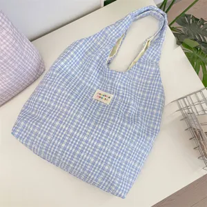 Detailopname van blauwe ruitjes canvas shopper, grote capaciteit voor dagelijks gebruik.