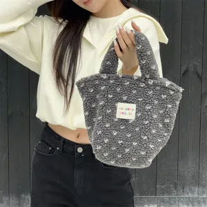 Cozy grey fleece handbag detail shot, showing soft texture and cute stitched fabric label.