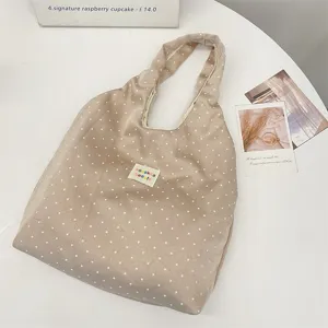 Λεπτομερής άποψη της casual τσάντας tote με βούλες, από μαλακό ύφασμα και μεγάλο χώρο.