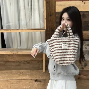 Fluffy striped tote bag detail, winter plush handbag lifestyle view, cozy casual accessory style.