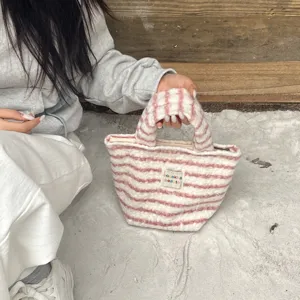 Detailed view of the pink and white striped plush handbag, showing soft cozy texture and cute style.