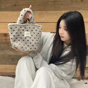 Close-up of cozy winter plush handbag with soft fleece fabric and charming blue star patterns.