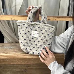 Plush tote bag fabric detail showing soft sherpa texture and cute floral pattern handle close up