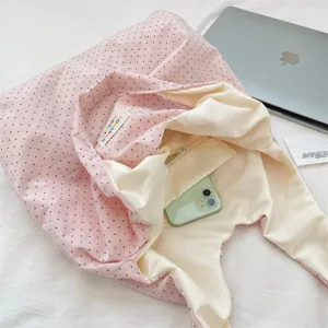 Detailed view of the pink polka dot canvas tote bag, featuring soft fabric and inner pocket.