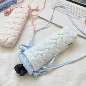 Detail view of quilted heart pattern camera pouch with checkered drawstring design.
